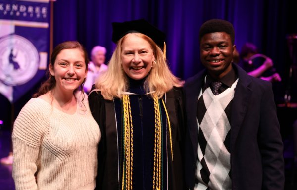 Graduate student with faculty at commencement