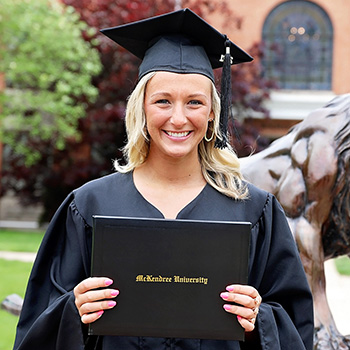 Female Student Holding Diploma at Commencement