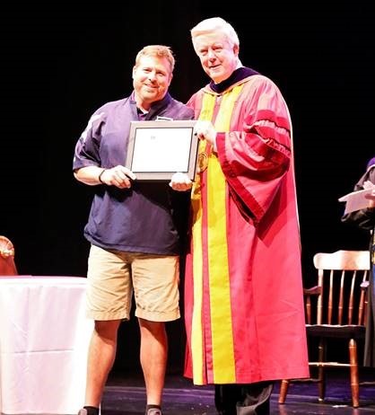 Tim Mullins accepts the President’s Award for Professional Excellence from Dr. James Dennis, university president